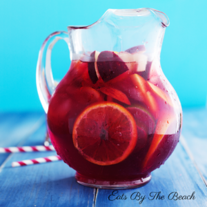 Clear pitcher of red wine sangria with slices of fruit