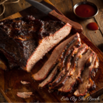 Slices of juicy, oven roasted beef brisket on a wooden board