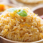 Wooden bowl with Basic Biryani Rice. Side view close up