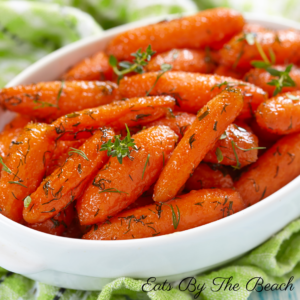 Bowl of baby carrots glazed with brown sugar, rum, and marmalade.