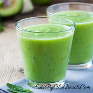 Glass of Sweet Green Smoothie with apple, kiwi, spinach, mint, avocado, and almond milk. This is a quick breakfast option by Eats By The Beach.