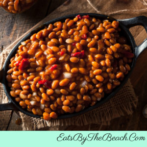 Dutch oven full of Brown Sugar And Bourbon Baked Beans - made with bacon, brown sugar, onions, red bell pepper, and bourbon.
