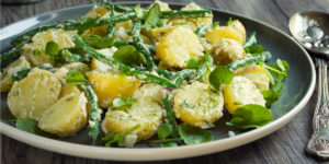 A healthy and easy side dish, a plate of tangy, green bean and potato salad with a mustard based vinaigrette and garnished with microgreens.