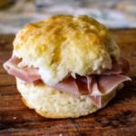 Platter of Country Ham and biscuits - homemade Southern-style biscuits with thinly sliced country ham nestled inside.