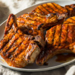 A platter of grilled bbq pork chops - bone-in pork chops with a homemade dry rub and basting sauce are so flavorful, juicy, and tender.