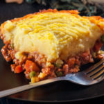 A casserole dish of comforting Shepherd's Pie - ground beef and veggies in a rich gravy and topped with a smooth, cheesy, creamy mashed potato topping.