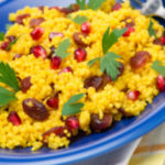 Curried Couscous with jeweled fruit - couscous spiced with curry powder, sauteed onions, garlic, raisins, and fresh pomegranate seeds.