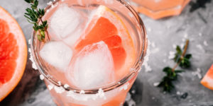 A Salty Dog Cocktail made with vodka, ruby red grapefruit juice, a twist of lime and a splash of club soda, then garnished with a salted rim and wedge of red grapefruit.