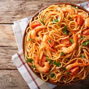 Bowl of Shrimp Fra Diavolo - juicy shrimp sauteed in a spicy, fresh tomato sauce served over pasta and garnished with parsley and Parmesan cheese.