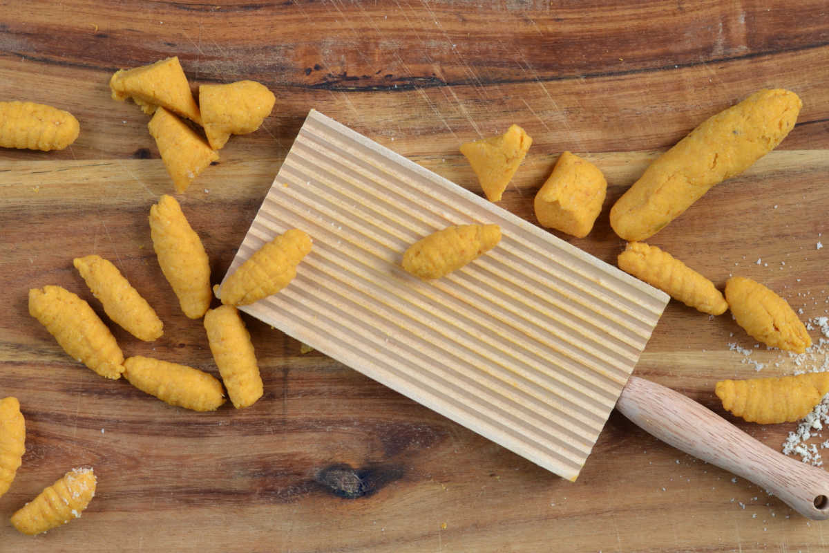 Homemade cavatelli using a ridged cavatelli board to roll the pasta down the ridges.