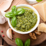 A bowl of fresh pesto sauce with parmesan cheese, lemon juice, spinach, basil, and garlic. Perfect for pasta, on a pizza, drizzled over vegetables, or to top scrambled eggs.