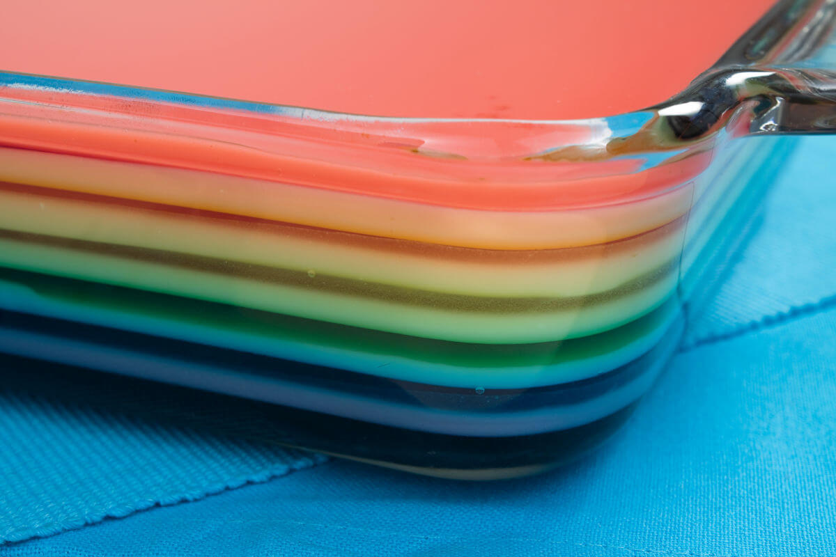Glass pan of Pride jello salad- fruit jello layers with a creamy layer in between.