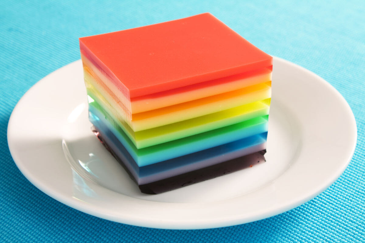 Glass pan of Pride jello salad- fruit jello layers with a creamy layer in between.