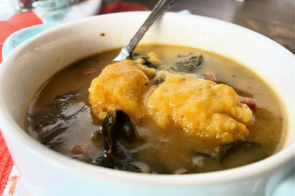 Bowl of stewed Beans And Greens With Corn Dodgers - a cornmeal dumpling