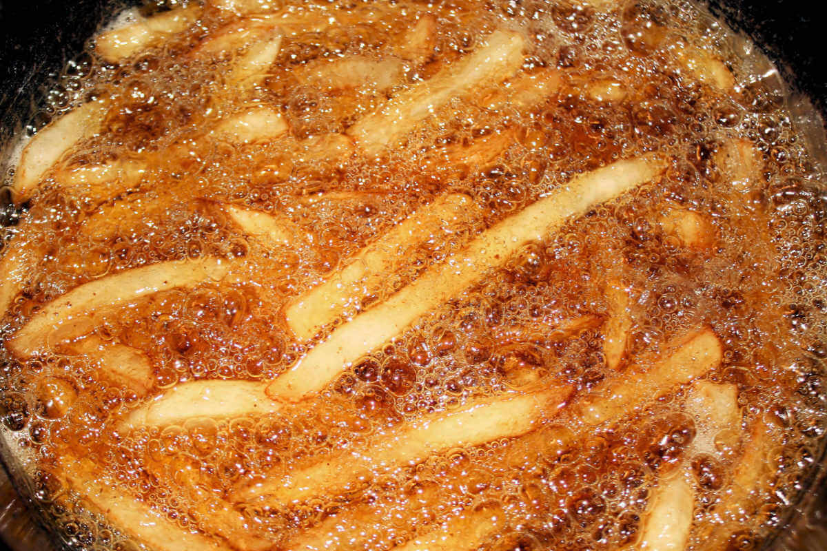 Potatoes in a deep fryer for Parmesan Truffle Fries.