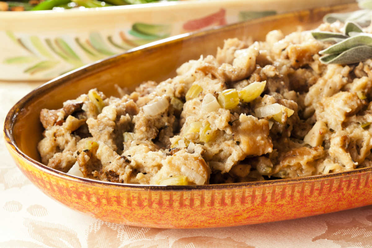 Brown casserole with Southern Cornbread Dressing and garnished with a fresh sage sprig.