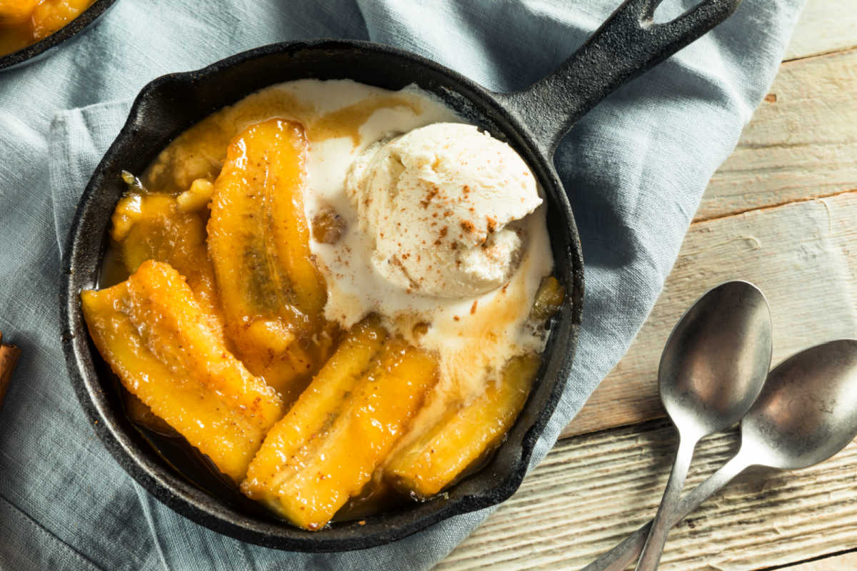 Small cast iron skillet with Individual Bananas Foster with a scoop of vanilla ice cream.  The perfect dessert for Mardi Gras.