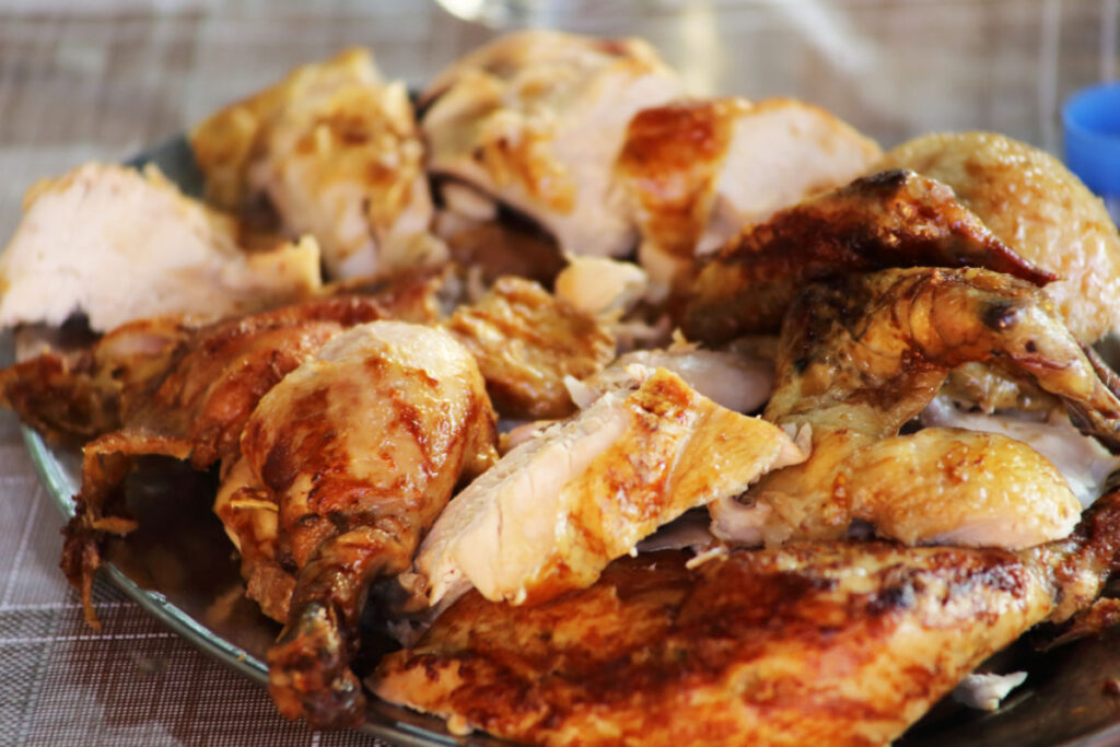 Cut up copycat Kenny Rogers Roasted Chicken on a silver platter.