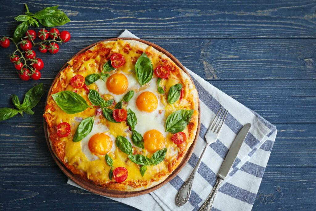 Closeup view of a Breakfast Margherita pizza with eggs baked on top. 