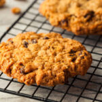 Classic oatmeal cookies cooling on a black wire rack.