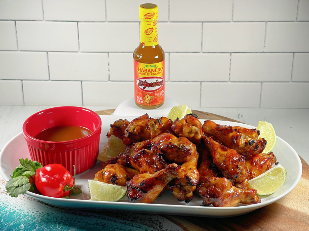 Platter of Tropical Tequila Fire Wings and a side of dipping sauce made with El Yucateco Habanero and Pineapple Hot Sauce