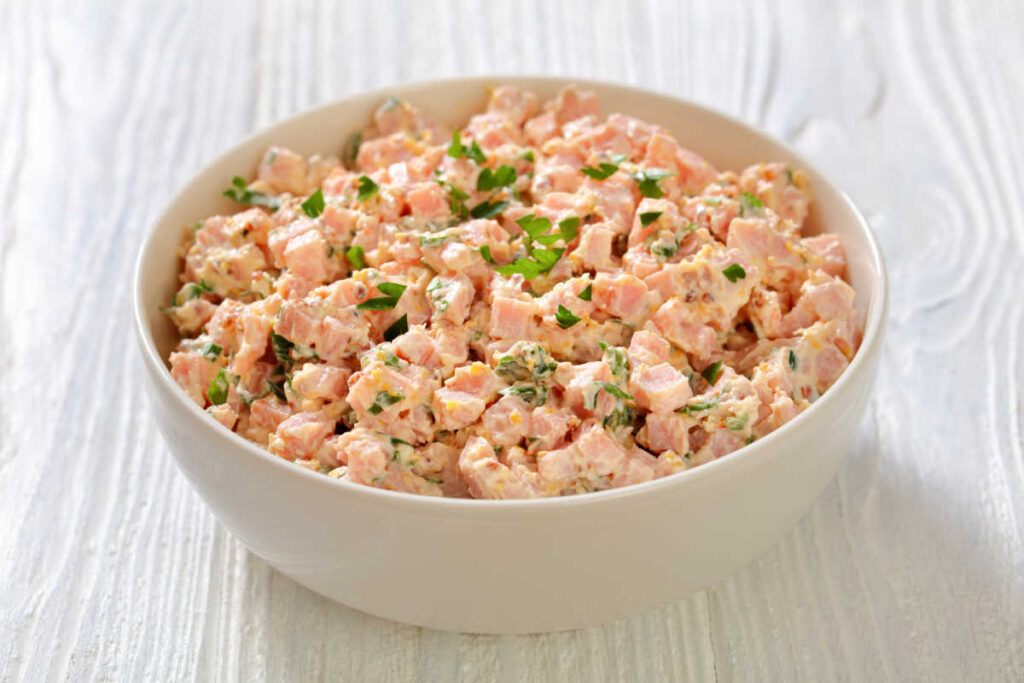 Old fashioned ham salad in a white bowl. Closeup view