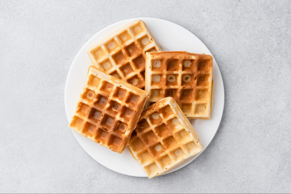 White plate with four homemade, fluffy, golden panckes.